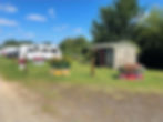 The campsite, with a shed, caravan and flower beds