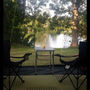 Chairs and a table in the shade by the lake